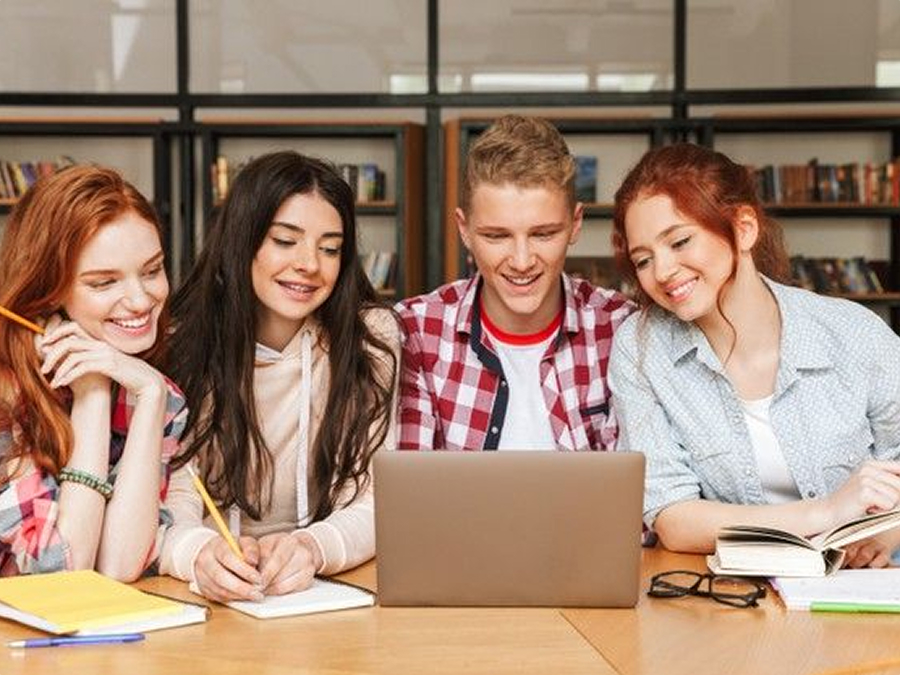 Students learning together around a laptop
